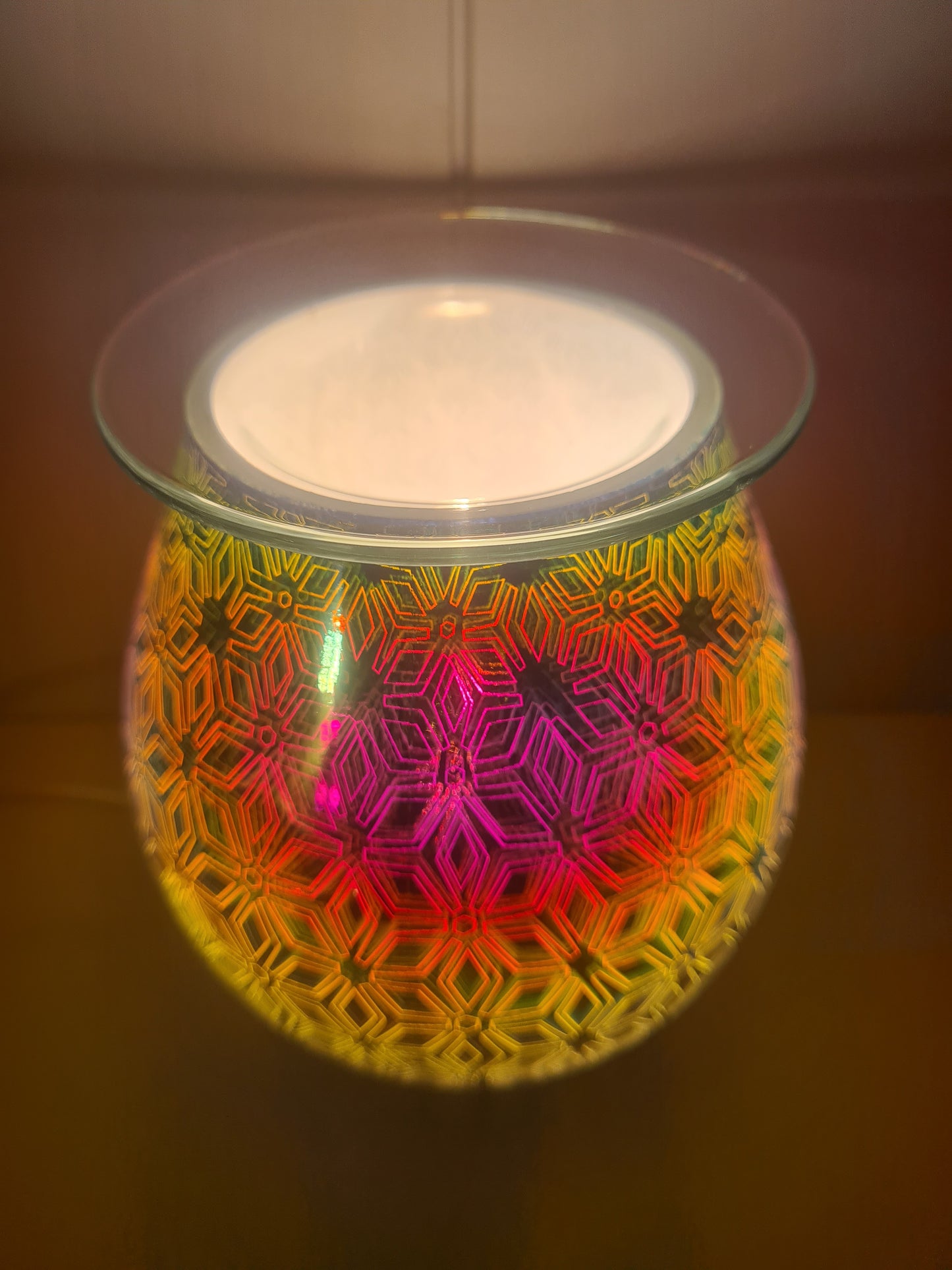 Electric wax or oil warmer lights up to display a colourful geometric flower pattern