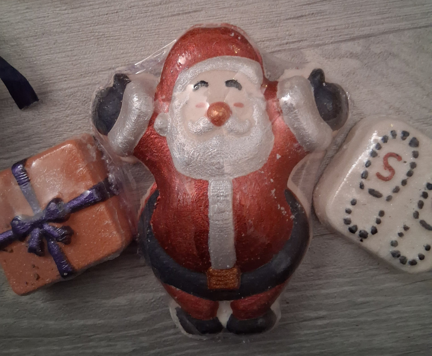 Santa Claus bath bomb, present bath bomb and santa boot print bath bomb on a wooden surface
