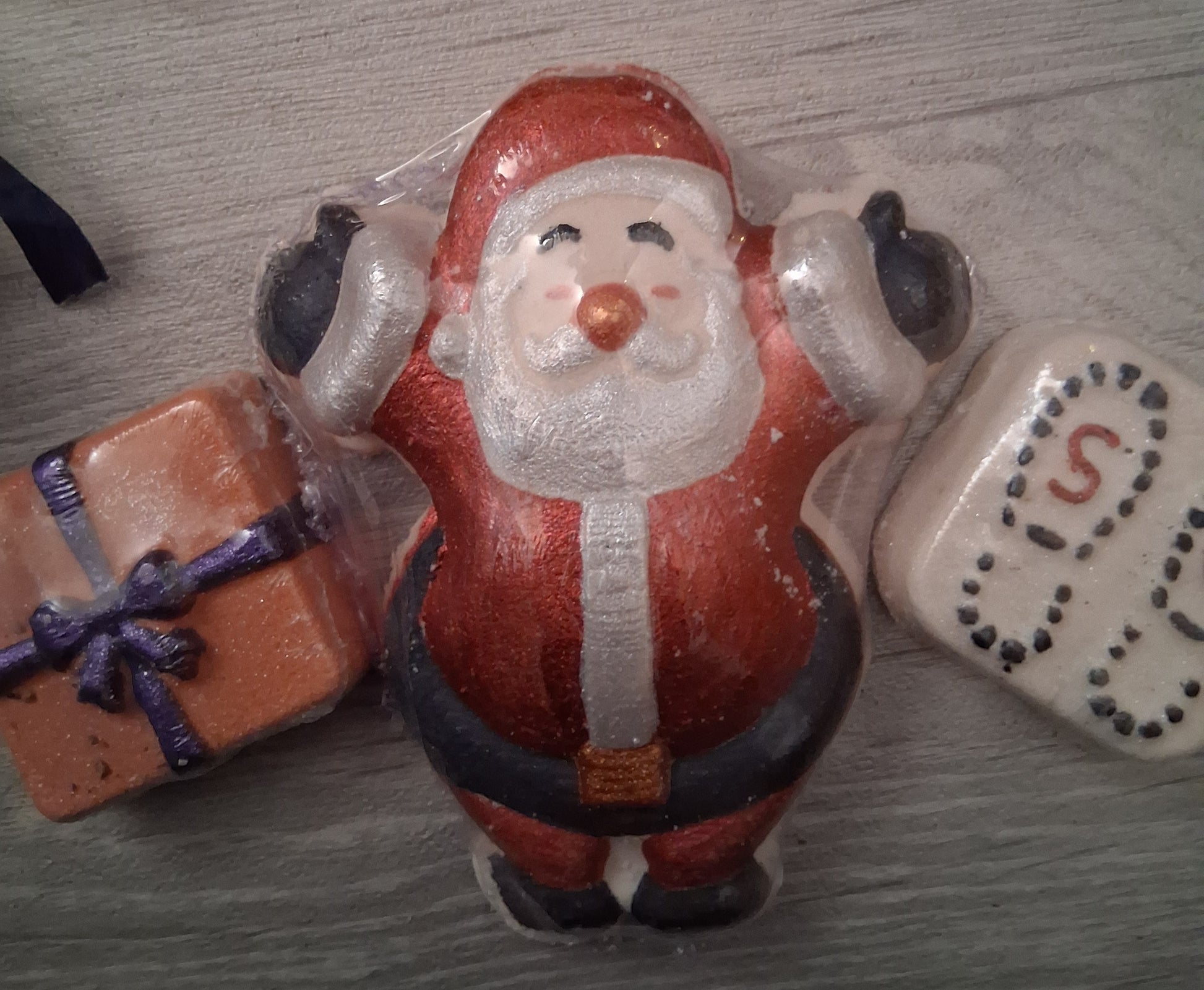 Santa Claus bath bomb, present bath bomb and santa boot print bath bomb on a wooden surface